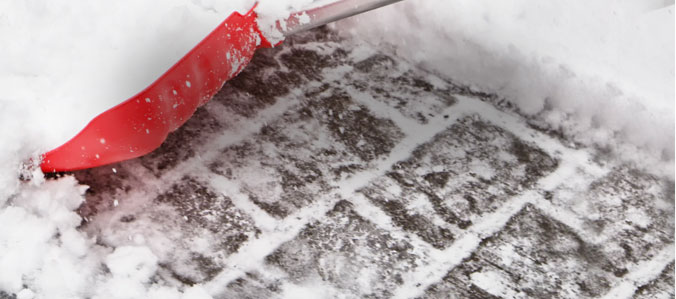 snow and ice removal with red shovel