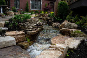 Large waterfall water feature beside a pathway surrounded by rocks