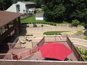 Aerial view of backyard landscaping with retaining walls and seating areas